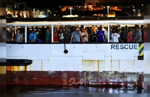 مهاجرون ينزلون من سفينة الإنقاذ أوبن آرمز على جزيرة لامبيدوزا الإيطالية